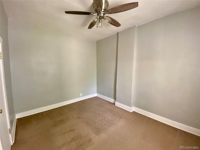 spare room with baseboards, a ceiling fan, and dark carpet