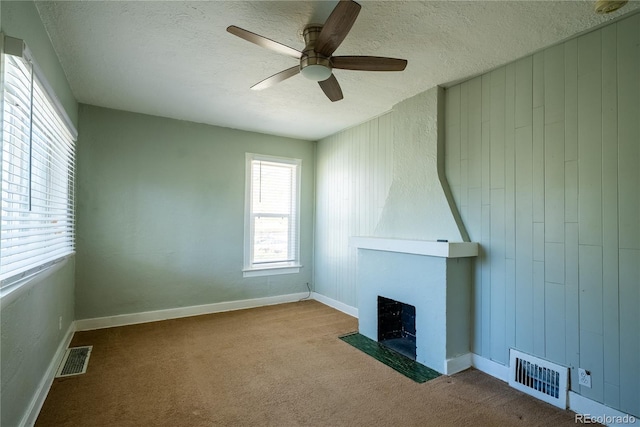 unfurnished living room with visible vents, ceiling fan, and a textured ceiling