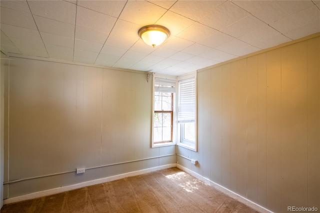 spare room featuring carpet floors and baseboards