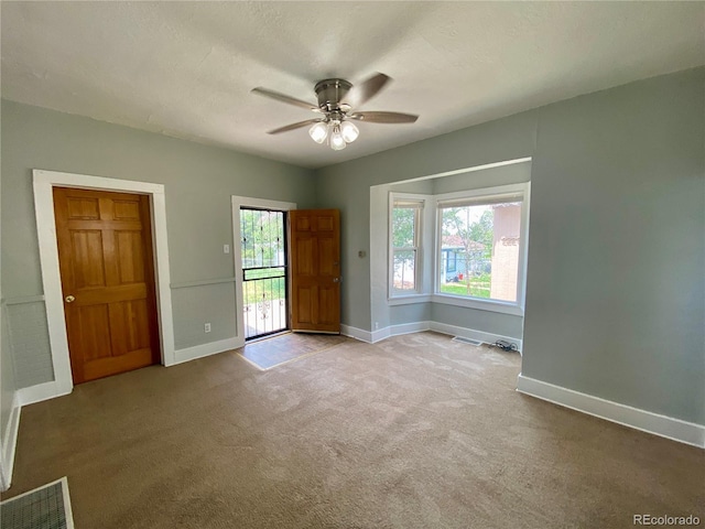unfurnished room featuring visible vents, ceiling fan, carpet flooring, and baseboards