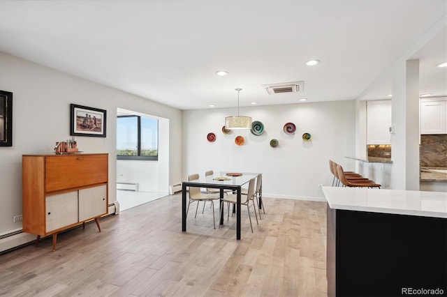 dining area featuring light hardwood / wood-style flooring and a baseboard heating unit