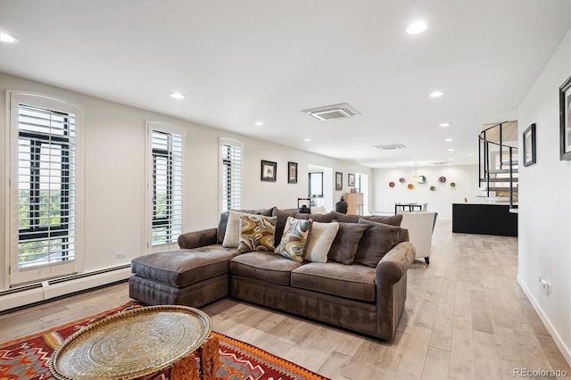 living room featuring light wood-type flooring and a baseboard heating unit