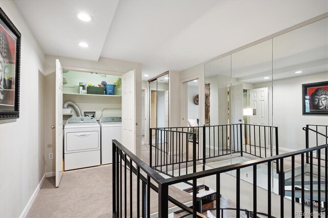 corridor with light carpet and washing machine and clothes dryer