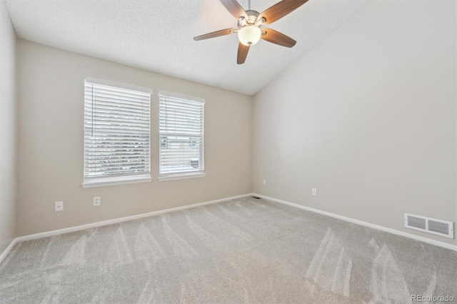 empty room featuring a textured ceiling, light colored carpet, and ceiling fan