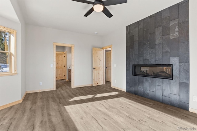 unfurnished living room with a fireplace, light hardwood / wood-style flooring, and ceiling fan