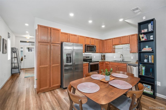 1106 Oak Cir, Lakewood, CO 80215 - kitchen with appliances with stainless steel finishes, light wood finished floors, open shelves, brown cabinets, and recessed lighting