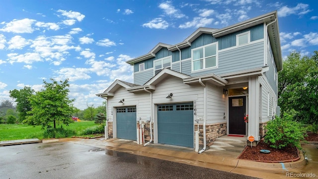 1106 Oak Cir, Lakewood, CO 80215 - view of front facade featuring board and batten siding, stone siding, and asphalt driveway
