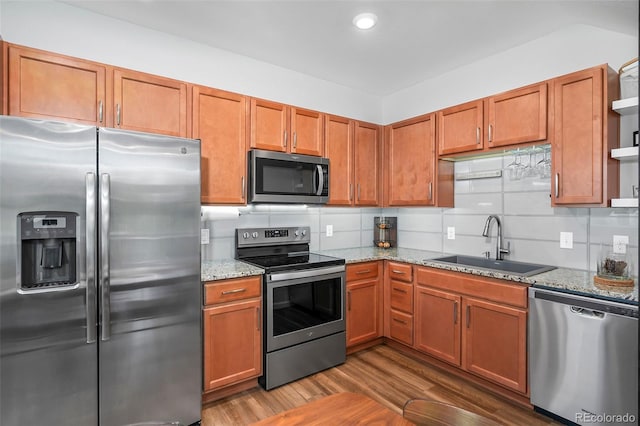1106 Oak Cir, Lakewood, CO 80215 - kitchen featuring appliances with stainless steel finishes, open shelves, tasteful backsplash, wood finished floors, and light stone countertops