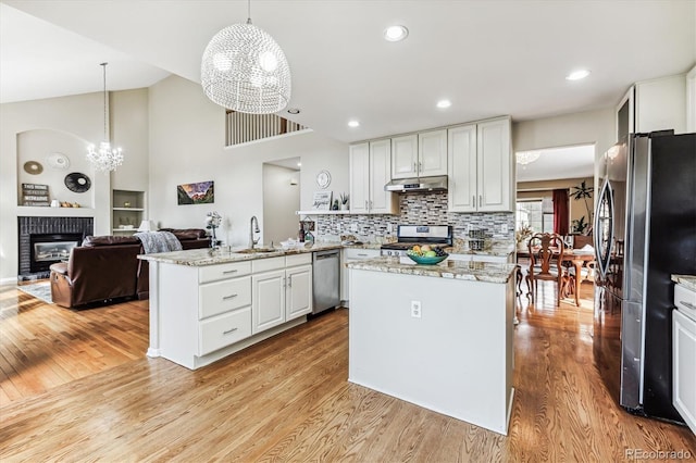 kitchen featuring pendant lighting, light hardwood / wood-style flooring, stainless steel appliances, and a chandelier