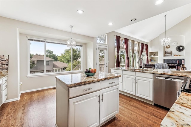 kitchen with hanging light fixtures, dishwasher, hardwood / wood-style floors, white cabinetry, and sink