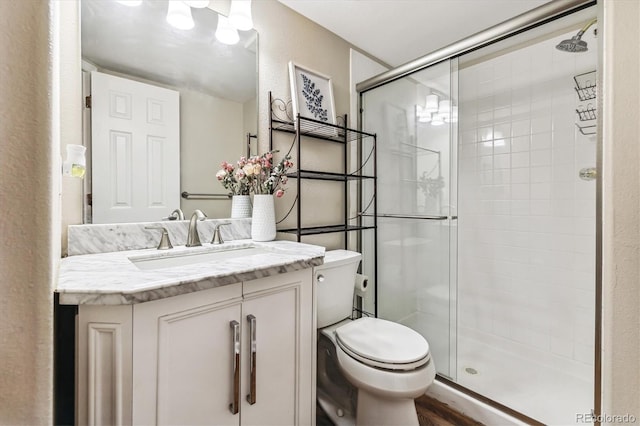 bathroom with vanity, toilet, hardwood / wood-style floors, and walk in shower