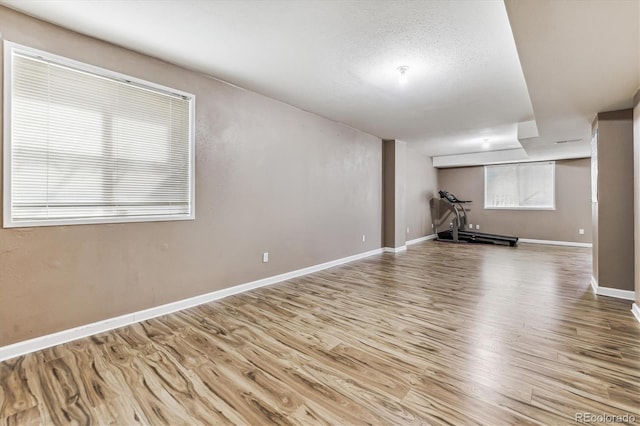 basement featuring a textured ceiling and light wood-type flooring