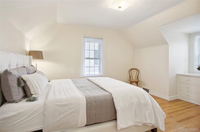 bedroom with lofted ceiling and light hardwood / wood-style flooring