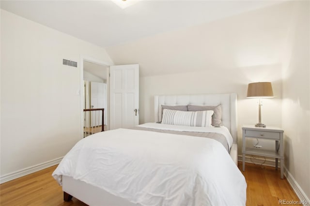 bedroom featuring wood-type flooring and vaulted ceiling