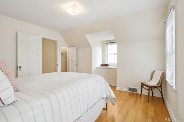 bedroom featuring light hardwood / wood-style flooring and vaulted ceiling