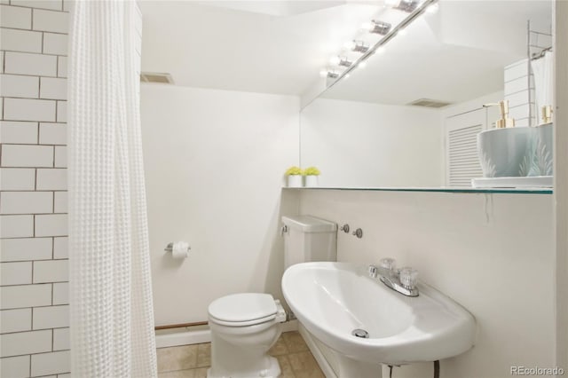 bathroom with tile patterned flooring, toilet, sink, and a shower with shower curtain