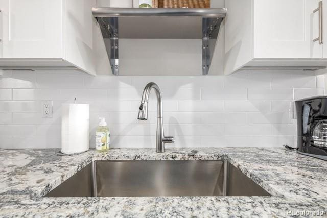 828 Grand Ave Unit 201C, Grand Lake, CO 80447 - kitchen view of a sink, white cabinets, backsplash, and light stone countertops