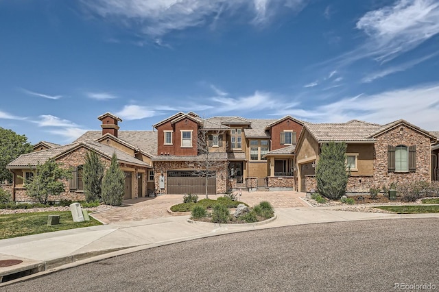 3181 Firenze Pl, Highlands Ranch, CO 80126 - view of front facade with driveway, stone siding, stucco siding, an attached garage, and a tiled roof