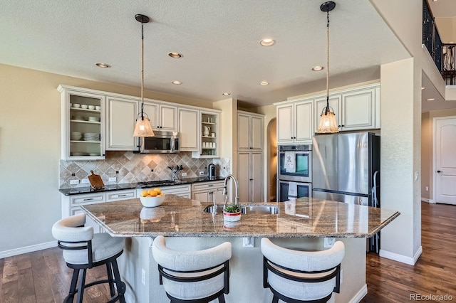 3181 Firenze Pl, Highlands Ranch, CO 80126 - kitchen featuring stainless steel appliances, a sink, dark wood-type flooring, tasteful backsplash, and baseboards