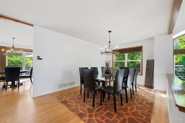 dining area with wood-type flooring and a chandelier