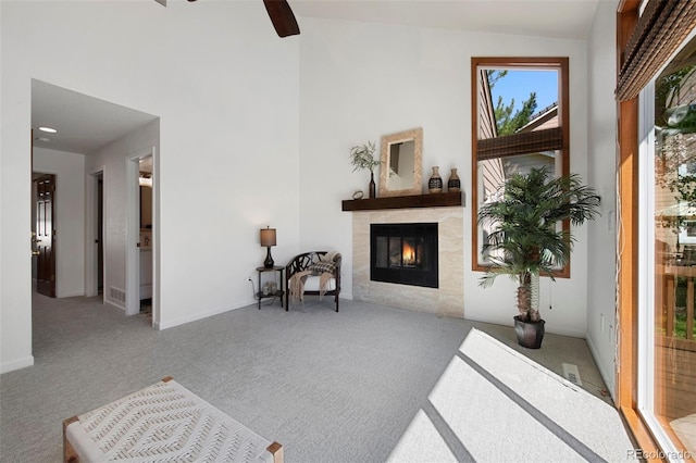 interior space with lofted ceiling, a tiled fireplace, light carpet, and ceiling fan