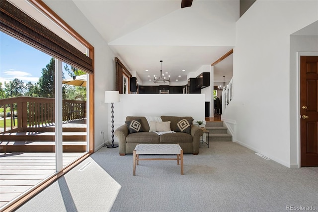 living room featuring light colored carpet, vaulted ceiling, and a chandelier