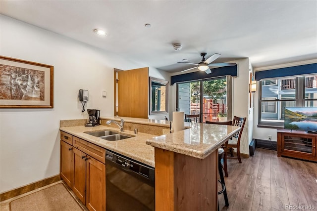 kitchen with dishwasher, a kitchen breakfast bar, kitchen peninsula, sink, and dark hardwood / wood-style flooring