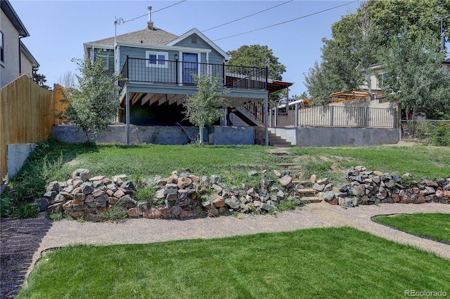 rear view of house featuring a yard and a deck