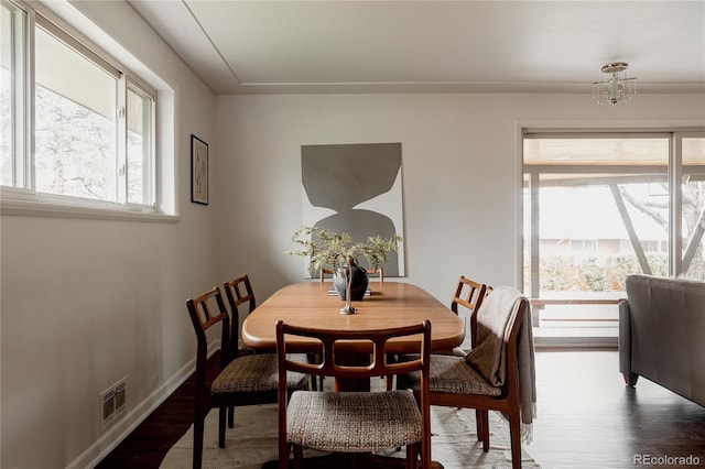 6530 W 26th Ave, Edgewater, CO 80214 - dining space featuring wood finished floors, a chandelier, and baseboards