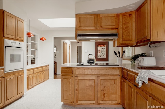 6530 W 26th Ave, Edgewater, CO 80214 - kitchen with white oven, under cabinet range hood, a skylight, light countertops, and a peninsula
