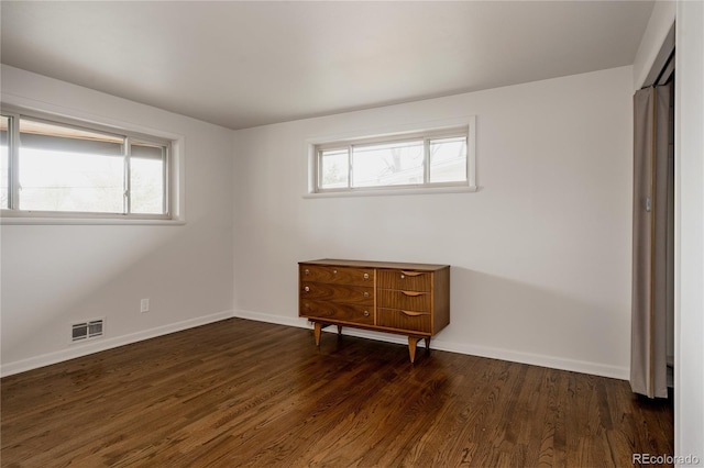 6530 W 26th Ave, Edgewater, CO 80214 - unfurnished bedroom featuring multiple windows, wood finished floors, and baseboards