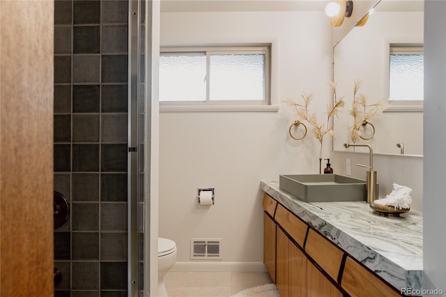 6530 W 26th Ave, Edgewater, CO 80214 - bathroom with tile patterned flooring, vanity, toilet, baseboards, and tiled shower