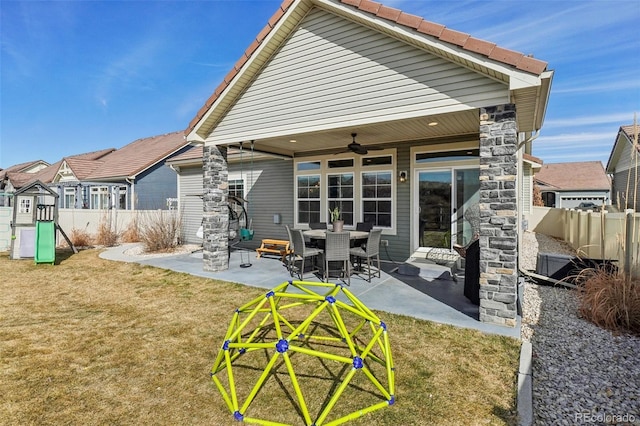 back of house featuring a playground, a yard, a ceiling fan, a patio area, and fence