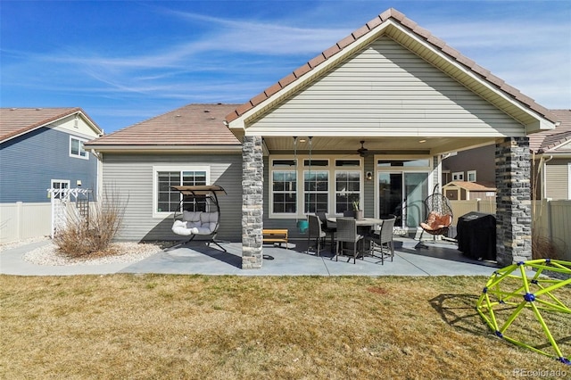 rear view of house with a patio area, ceiling fan, fence, and a lawn