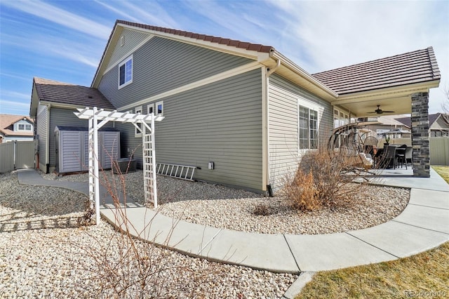 view of side of home with a patio area, fence, and a pergola