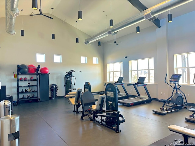 gym featuring baseboards and high vaulted ceiling