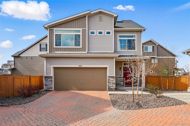 10123 Zeno St, Commerce City, CO 80022 - view of front facade with a garage, stone siding, decorative driveway, and board and batten siding