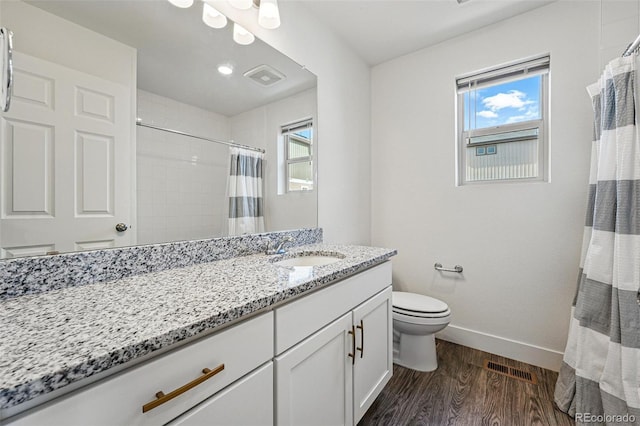 10123 Zeno St, Commerce City, CO 80022 - bathroom featuring wood finished floors, baseboards, healthy amount of natural light, and toilet