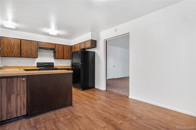 kitchen with black appliances, light wood-type flooring, sink, and exhaust hood