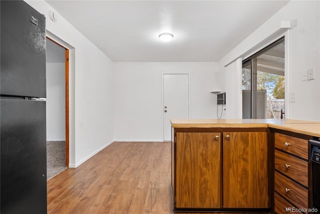 kitchen featuring light wood-type flooring and black appliances