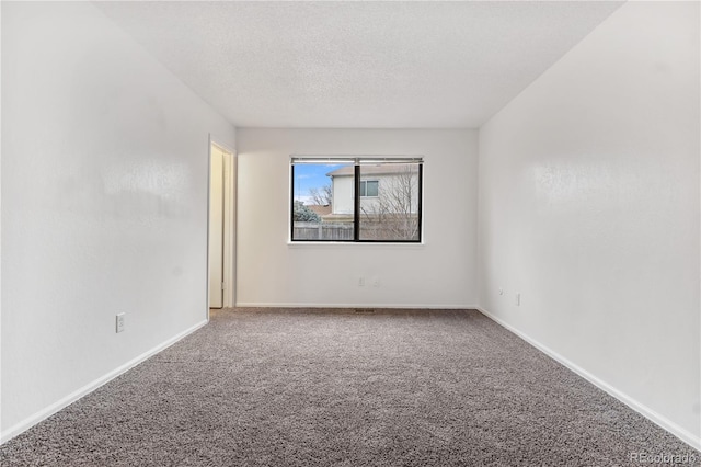 empty room with a textured ceiling and carpet floors