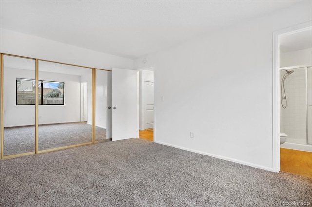 unfurnished bedroom featuring carpet flooring, a closet, and ensuite bath