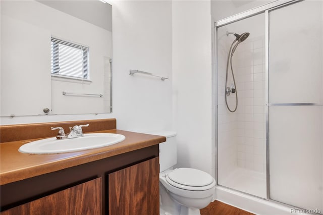 bathroom with vanity, toilet, and a shower with shower door