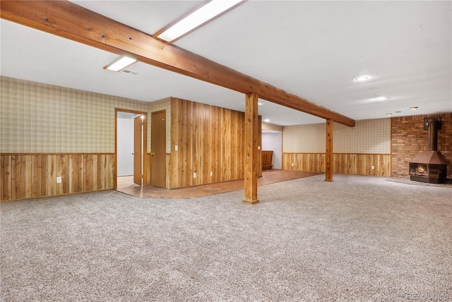 basement with light carpet and a wood stove