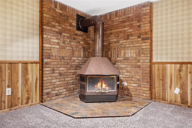 room details featuring carpet, a wood stove, and wood walls