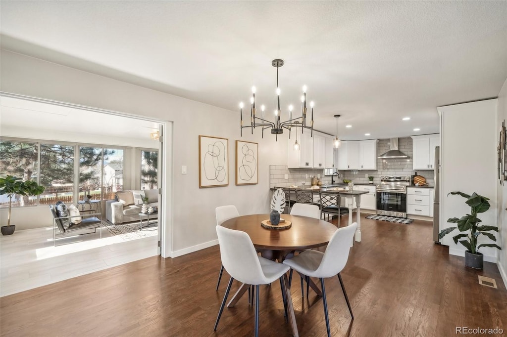 dining area with hardwood / wood-style floors and a notable chandelier