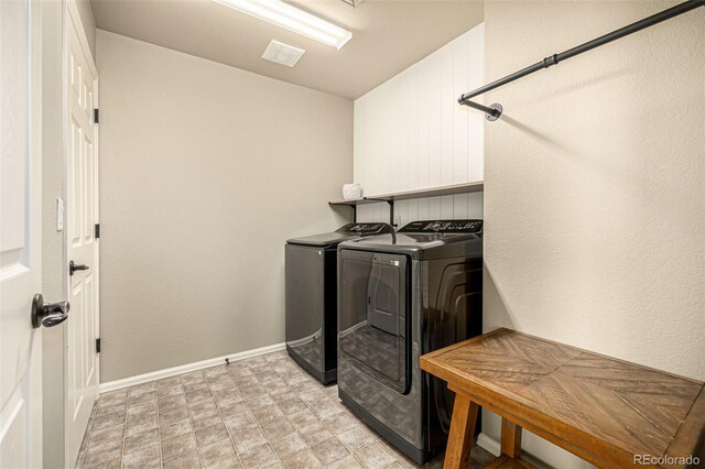 clothes washing area featuring washer and dryer and baseboards