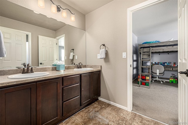 bathroom with double vanity and baseboards
