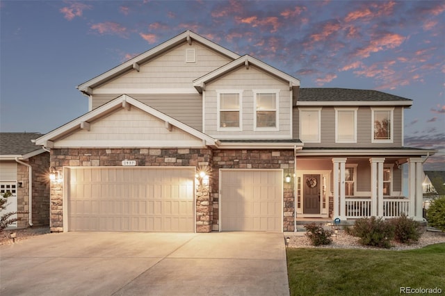 craftsman house featuring a porch, concrete driveway, stone siding, a lawn, and an attached garage
