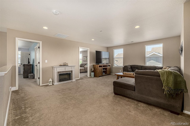 carpeted living area with a fireplace, baseboards, and recessed lighting